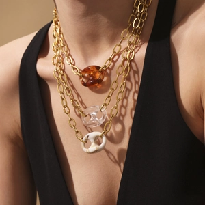 Driedelige gouden kettingenset met hangers van amber en marmerhars