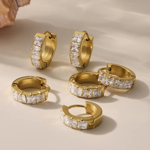 Classic gold hoop earrings with 5A cubic zirconia set on warm beige background