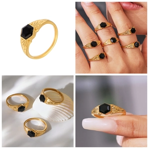 Detailed view of vintage gold ring with hexagonal black stone and baroque floral embossing