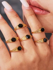 Set of six gold-tone rings with hexagonal black stones and floral relief textures