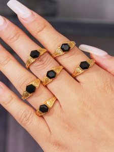 Macro detail of retro gold rings with hexagonal black onyx and embossed leaf patterns