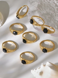 Macro detail of eight gold vintage rings with hexagonal black stones and shell decor