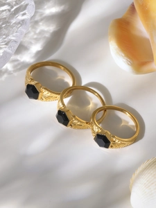 Detailed view of three vintage gold rings with black gemstones and embossed textures