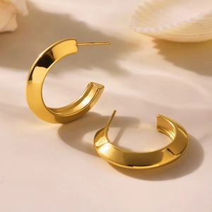 Minimalist 18k gold plated stainless steel C-shape hoop earrings on beige surface