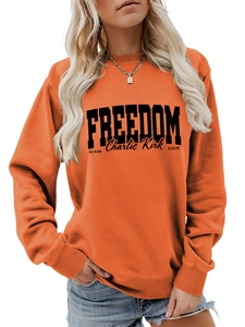 Detailed view of the orange long-sleeve sweatshirt featuring black Freedom lettering print