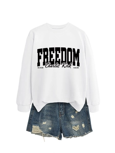 Detail of white cotton sweatshirt with black Freedom print and ripped denim shorts