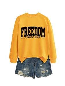 Detail of yellow Freedom Charlie Kirk sweatshirt with ribbed collar and denim shorts