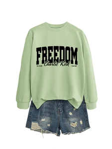 Detail of light green sweatshirt with Freedom Charlie Kirk print and denim shorts