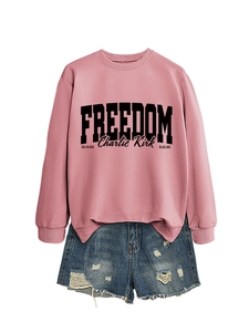 Detail of pink sweatshirt with black Freedom text and Charlie Kirk signature print