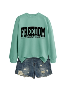 Detailed view of mint green sweatshirt with freedom print and distressed denim shorts