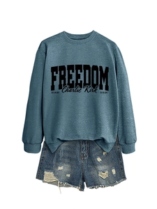Close-up of Charlie Kirk Freedom print on blue sweatshirt with ripped denim shorts