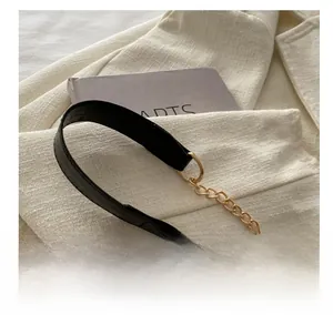 Detail of black leather and gold metal chain strap on a chic quilted shoulder bag