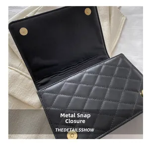 Detail shot of the black quilted handbag featuring golden magnetic snap closures