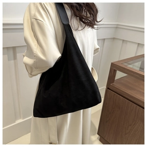 Close-up of black matte suede hobo bag with wide shoulder strap showing texture