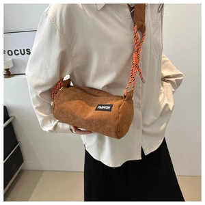Close-up of caramel corduroy cylinder bag with woven orange and white rope strap