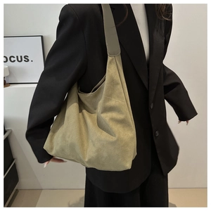 Detail of suede khaki hobo bag with wide shoulder strap showing soft texture and large capacity