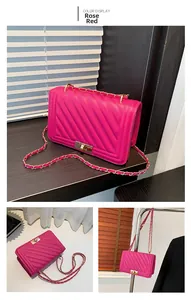 Macro view of rose red V-quilted leather bag featuring golden lock and chain strap