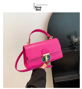 Dettaglio borsa in pelle PU rosa con chiusura a scatto dorata e manico superiore liscio