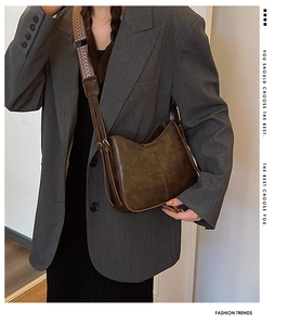 Detailed view of the dark brown PU leather crescent bag with patterned wide strap