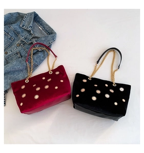 Détail de sacs cabas en velours avec rivets fleurs de soleil et chaîne dorée