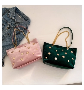 Détail de cabas en velours rose et vert avec clous soleil et anses en chaîne dorée