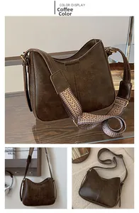 Detail of coffee brown PU leather hobo bag with vintage texture and ethnic woven strap