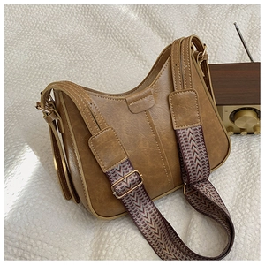 Detail of vintage brown crossbody bag with wide geometric patterned shoulder strap