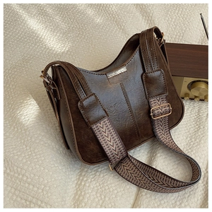 Detail of vintage brown shoulder bag with textured jacquard strap and gold hardware