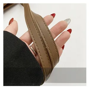 Detail shot of brown leather tote bag strap featuring high-quality double stitching craft