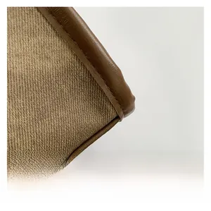 Macro shot of brown twill fabric texture and leather edging with precision stitching