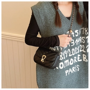 Détail du sac en similicuir noir à matelassage en V avec chaîne dorée et fermoir mors