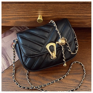 Détail du sac en cuir noir matelassé avec chaîne dorée et couture unique en forme de V