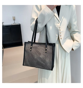 Detail of dark grey retro tote bag with matte texture and reinforced black straps