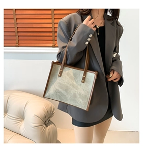 Vintage tote bag with marble texture detail and brown leather straps worn with grey blazer