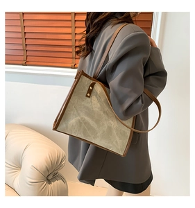 Detailed view of the large vintage tote bag with contrast leather trim on a model