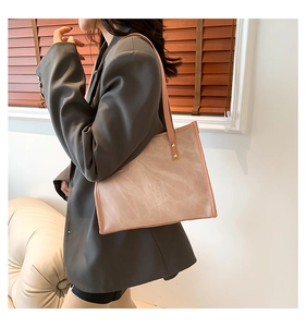 Close-up of pink marbled tote bag with slim shoulder straps and gold rivet accents