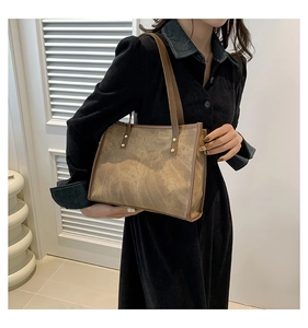 Retro marble texture tote bag with brown straps and gold rivets worn on model in black dress