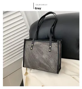 Close-up of grey marble texture canvas tote with black leather trim and gold rivets