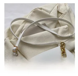 Détail du sac selle en cuir PU blanc avec boucle dorée en D et bandoulière chaîne