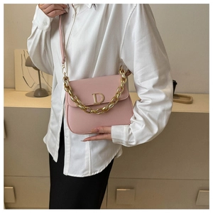 Détail du sac selle en cuir rose avec logo D doré et bandoulière chaîne épaisse