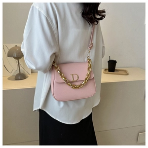 Détail du sac selle en cuir rose clair avec grosse chaîne dorée et boucle lettre D