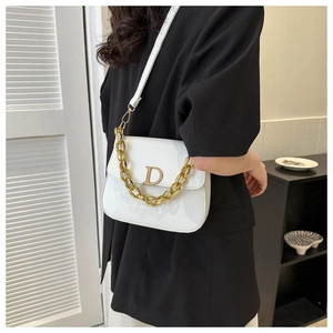 Détail du sac selle en cuir verni blanc avec fermoir D doré et bandoulière chaîne