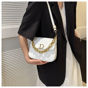 Détail du sac selle en cuir blanc avec boucle D dorée et poignée chaîne épaisse