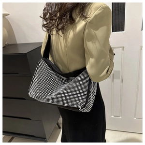 Vue latérale d'un sac oreiller en strass noirs porté à l'épaule montrant la taille réelle
