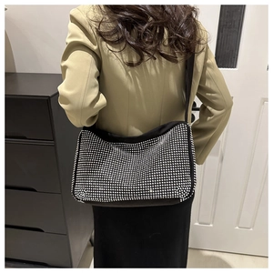 Détail des strass argentés sur le sac à bandoulière noir porté par le mannequin