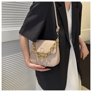 Détail du sac selle beige en simili cuir avec boucle D dorée et poignée chaîne épaisse