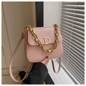 Vue détaillée du sac selle en cuir rose avec logo D doré et bandoulière chaîne