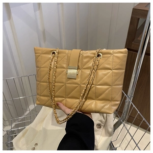 Dettaglio borsa tote trapuntata marrone chiaro con catena dorata e chiusura metallica