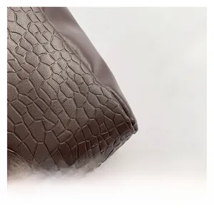 Macro detail of deep brown crocodile embossed leather with premium stitching craftsmanship