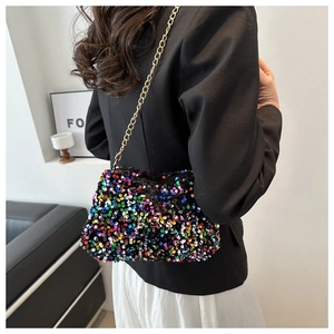 Detail of colorful sequin crossbody bag with gold chain strap worn by a model